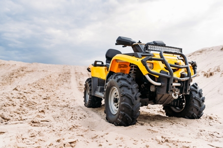 yellow all-terrain vehicle standing in desert