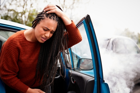 Female Motorist With Head Injury Getting Out Of Car After Crash stock photo