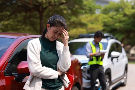 The woman's Car has broken down on the road and contact with the service. A young Asian woman and an insurance agent discussing car damage and an insurance claim. Car Insurance Claims Insurance Claims Assessment Officers examine and consider car accident