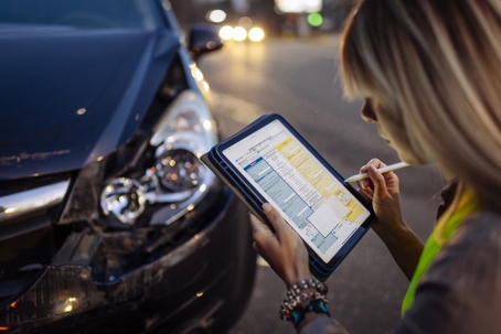 Woman filling accident report after car crash stock photo