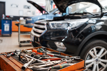 Mechanic tools in tray near car under repair stock photo