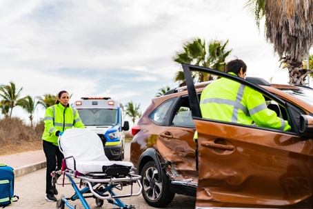 Paramedic arriving and helping victim on car accident stock photo