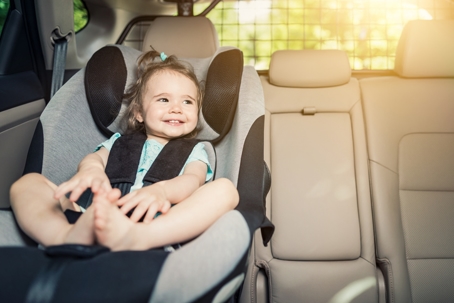 Infant baby girl buckled into her car seat. stock photo