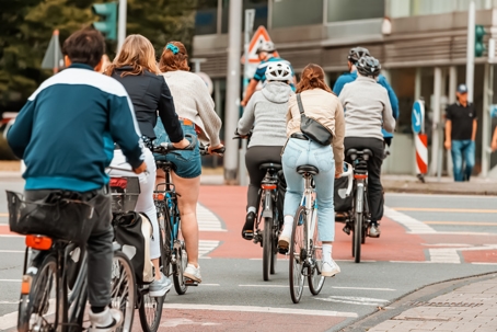 Many Cyclists cross the street and the road at the intersection at the traffic light signal. Road rules safety concept stock photo