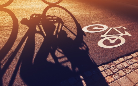 Shadow of unrecognizable cyclist riding a bike on bicycle lane