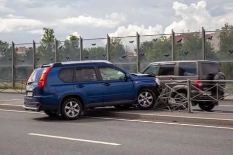Blue car got into accident and crashed into road fence. Front of car is damaged stock photo