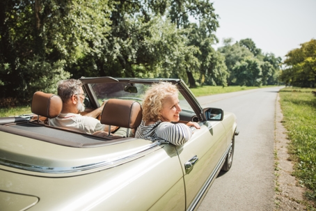 Older couple in a convertible car