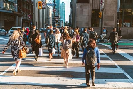 Crowd of unrecognisable people crossing street on traffic light