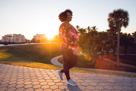 Curvy young black woman walking, jogging and running in the city public park stock photo