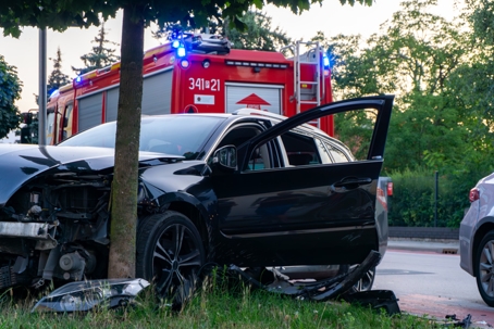 Damaged passenger car after road accident, fire brigade on scene stock photo