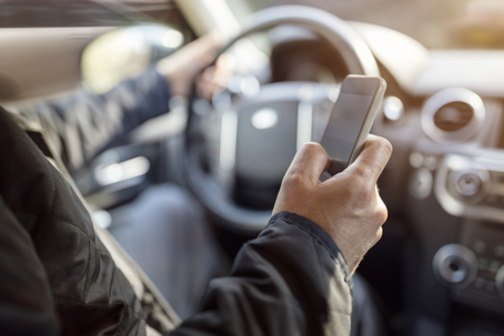 Texting while driving using cell phone in car stock photo