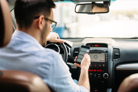 Transportation concept - man using phone while driving the car stock photo