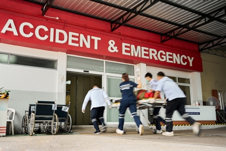 EMS team wheeling patient on stretcher into the hospital during an emergency stock photo