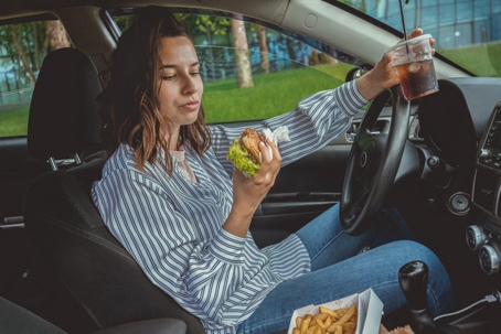 Woman eating while driving. Distracted Driver.