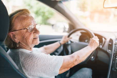 Elderly woman behind the steering wheel stock photo