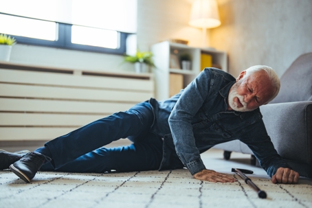 Old man suffering with pain and struggling to get up after falling down