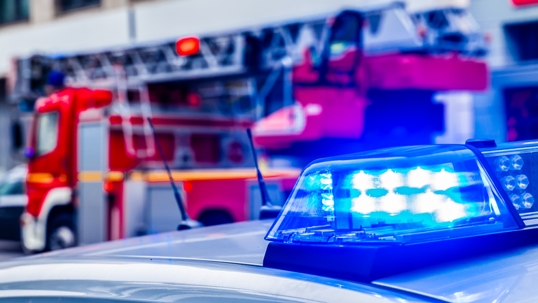 Blue Flash Light Of Police Car Against Red Fire Truck stock photo