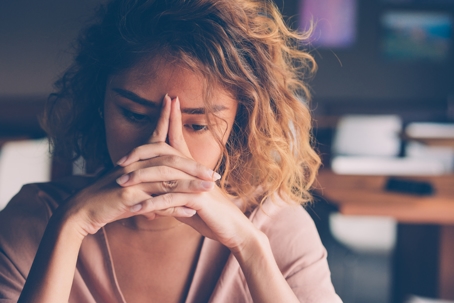 Tired Young Woman Leaning Head on Hands stock photo