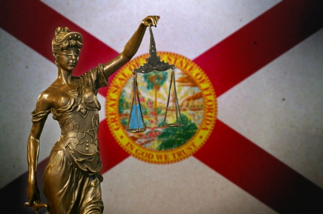 Lady of Justice Statue in front of the Florida State Flag
