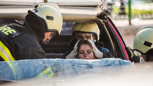 Two firefighters helping female driver stock photo