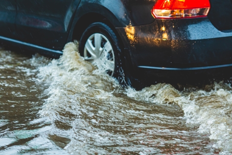 Car wheel in puddle. Torrential rain. stock photo