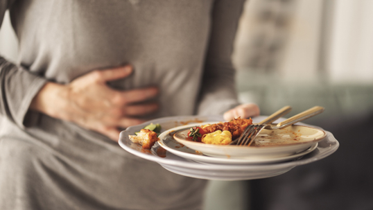 Woman with bloating and stomach pain after eating stock photo