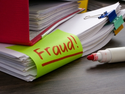 A folder and a stack of papers about finances or taxes with an inscription fraud.