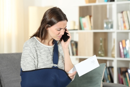 Sad disabled woman claiming on phone about notice stock photo