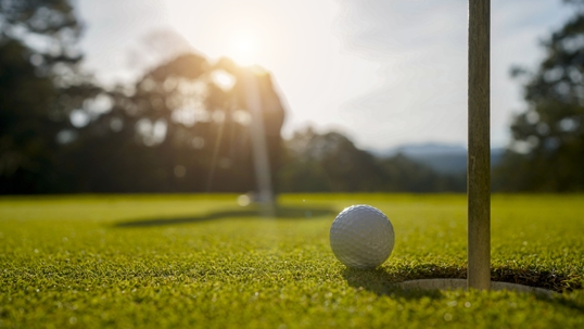 Golfer playing golf in the evening golf course, on sun set evening time. stock photo