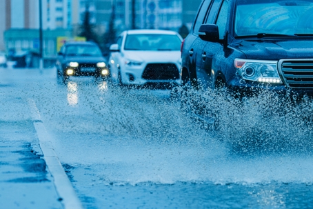 Splashes of water from passing car. Wet road. stock photo