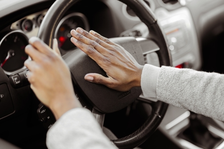 Hand Pushing on Steering Wheel Honking Horn
