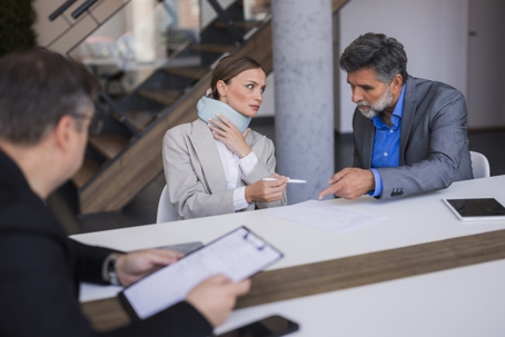 Woman with neck brace discussing legal claim with lawyer stock photo