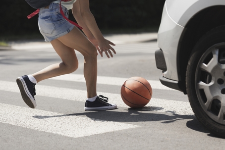 Young girl catching a basket ball on a pedestrian crossing stock photo
