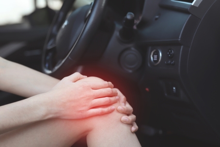 Woman has knee pain in the car stock photo