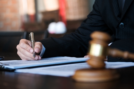 Legal counsel presents to the client a signed contract with gavel and legal law