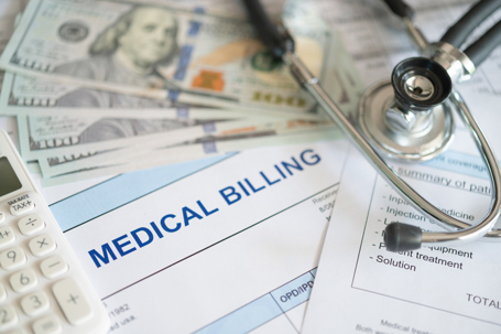 Medical billing document and dollar banknote, calculator, stathoscope. medical treatment expense concept. stock photo