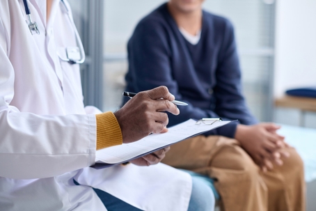 Doctor Holding Clipboard Consulting Child stock photo