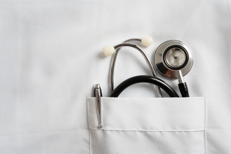 Stethoscope and pen in doctor robe pocket stock photo