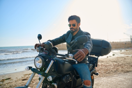 Man riding motorcycle near the beach during sunny day stock photo