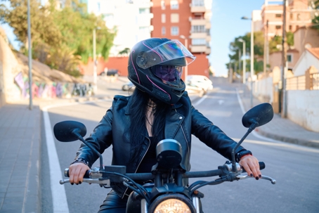 Stylish rider in leather jacket navigates urban road on a motorcycle stock photo