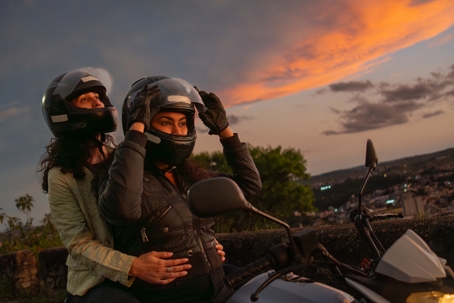 Two friends and the motorbike heading to the day’s last glow stock photo
