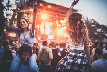 Happy female friends having fun on a music concert