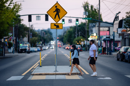 Pedestrians crosses street at cross walk stock photo