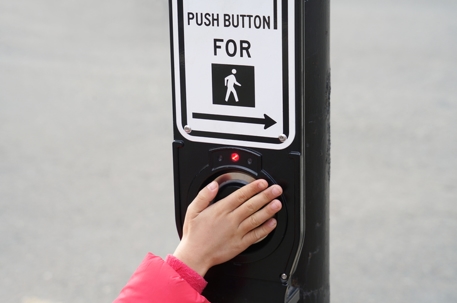 Kids hand push button of pedestrian crossing sign stock photo