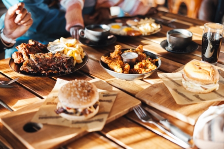 ast food, lunch or dinner on table at restaurant, people eating