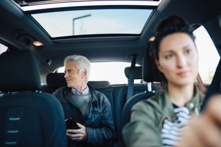 Senior man riding with a female carshare driver