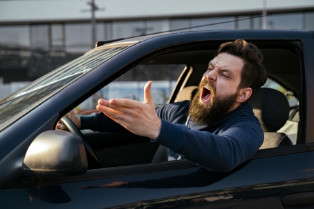 Bearded young man road raging , yelling from the car closeup shot stock photo