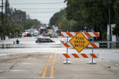 Hurricane Debby flooded street with road closed sign blocking driving of cars in Sarasota, Florida. Safety of transportation during natural disaster concept stock photo