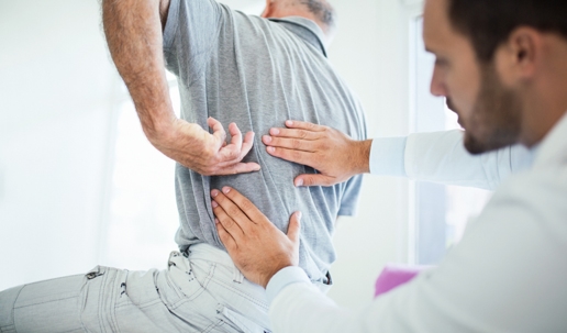 doctor examining a man with lower back pain