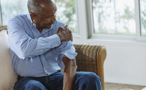 Senior African-American man with pain in his shoulder stock photo